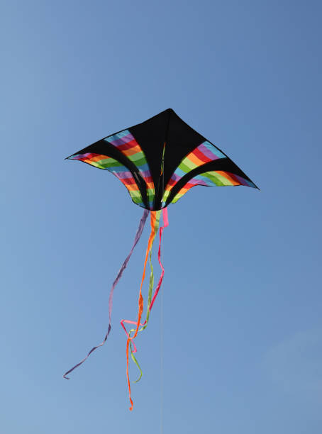 istock black kite with multicolored rainbow stripes flies high in the blue sky tied to a string 1431992454