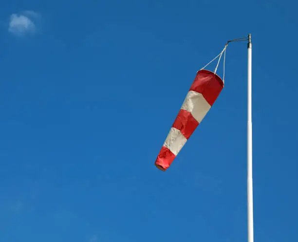 weather vane in white and red to indicate the direction of the wind and the blue sky in the background