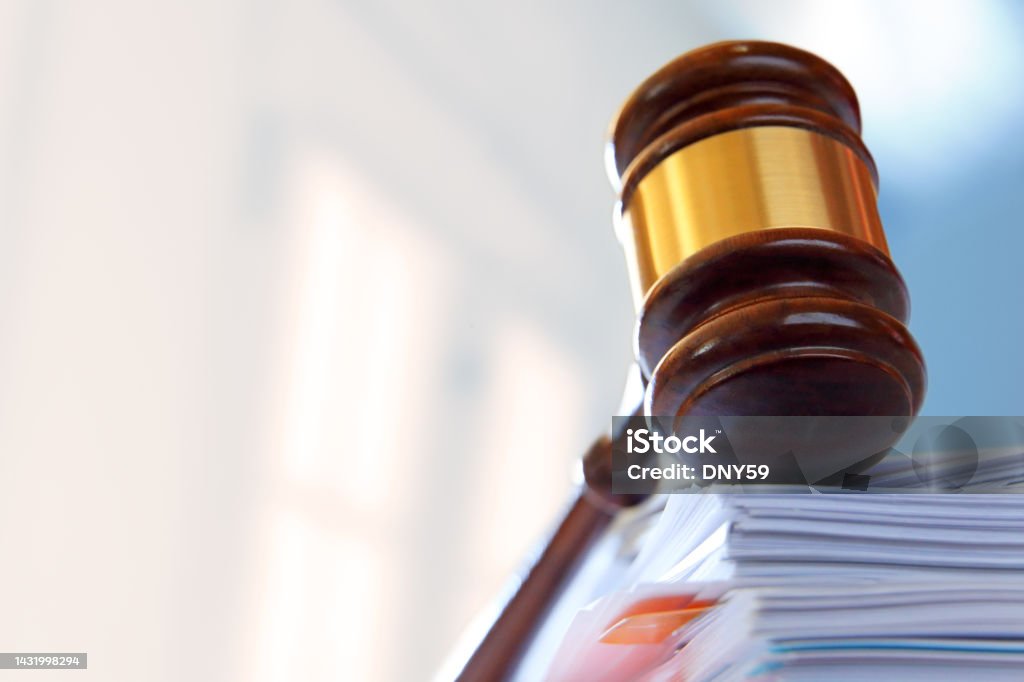 Gavel On Top Of Stack of Legal Documents A gavel, photographed with a very shallow depth of field, rests on top of a stack of file folders and legal documents. Legislation Stock Photo