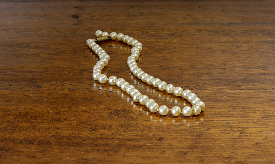 Pearl necklace on a wooden table.
