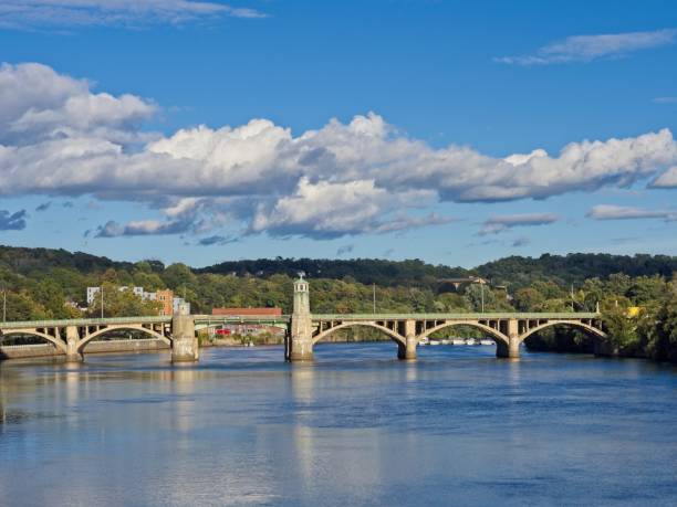 The Merrimack river between Haverhill and Bradford Massachusetts. The placid river in Essex county with railroad bridge in the background as it travels towards the Atlantic ocean.