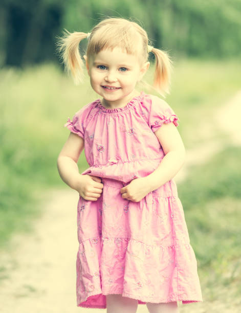 Cute little girl on the meadow in summer day