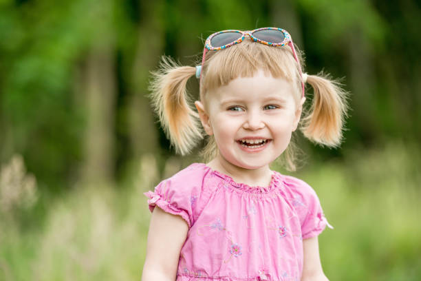 Cute little girl on the meadow in summer day