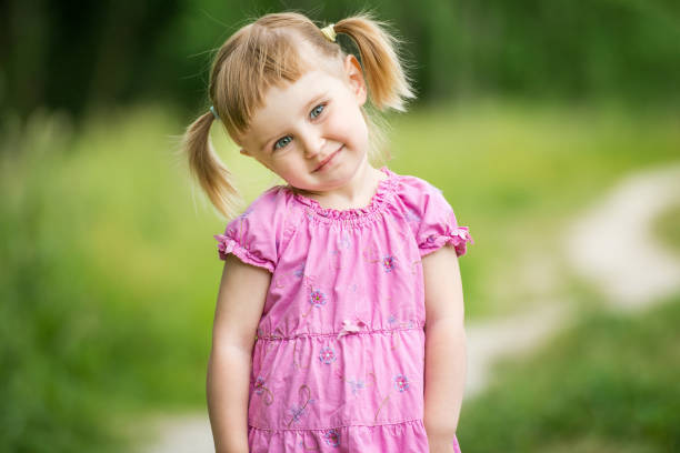 Cute little girl on the meadow in summer day