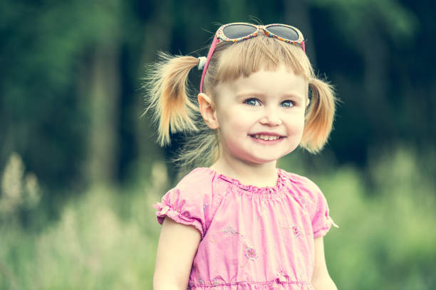 Cute little girl on the meadow in summer day