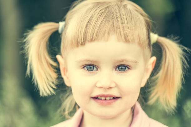 Cute little girl on the meadow in summer day