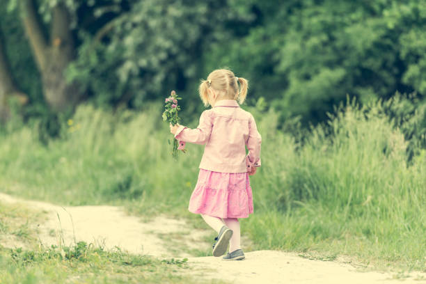 a asian girl picking and holding flowers on the meadow