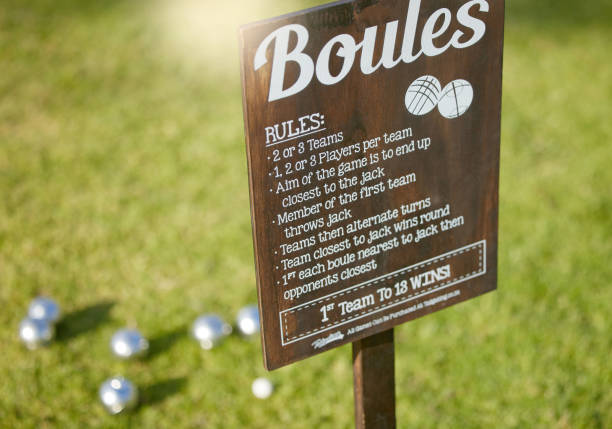 Boules sports, information sign and game rules in summer garden grass, backyard or nature environment park in France. Zoom, texture or wooden billboard with writing for exercise, fitness and training deportes de petanca, cartel informativo y reglas de juego en césped de jardín de verano, patio trasero o parque de entorno natural en francia. zoom, textura o valla publicitaria de madera con escritura para ejercicio, fitness y entrenamiento