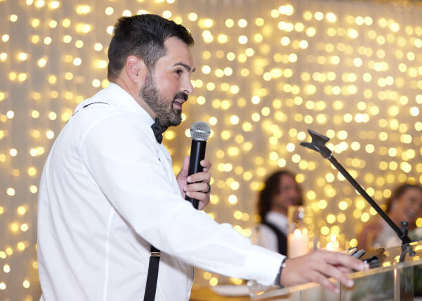 istock Wedding, speech and microphone with a best man giving a toast at a marriage reception or celebration event after a ceremony. Tradition, love and romance with a handsome young male talking to a crowd 1432006169