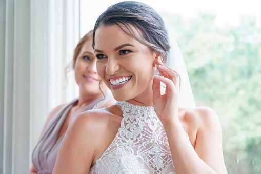 Hispanic customer smiling while using application on mobile phone in bridal studio