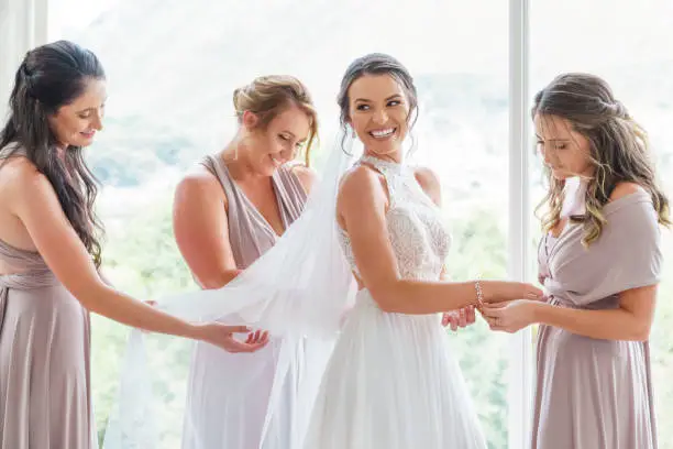 Photo of Wedding, bride and bridesmaids with a woman and her friends getting ready for a marriage ceremony or celebration event. Love, romance and tradition with a young female and her friend group inside