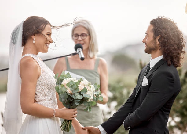 istock Wedding, love and bride makes a promise to groom with a commitment oath and holding hands. Couple, save the date and happy woman with a bouquet of flowers at her marriage celebration event outdoors 1432007065