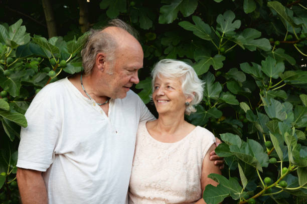 istock Senior couple standing  in front of fig tree 1432008560