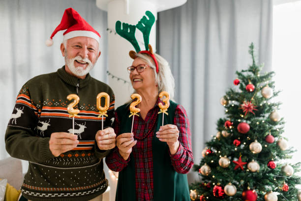 istock Senior couple holding numbers 2023 while celebrating New Year 1432009076