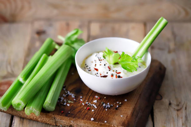Celery sticks with white sauce in a bowl. Healthy food. stock photo