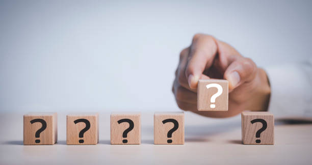 istock Hand hold Wooden cube block in question mark mean what on cement table background, column of wooden blocks with question sign mark. copy space,FAQ frequently asked questions, Answer, Information 1432010532