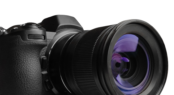 Modern mirrorless camera with zoom lens on white background closeup
