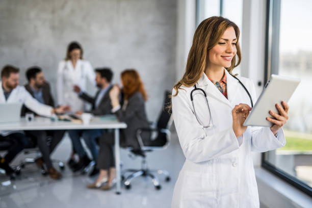 istock Female healthcare worker using digital tablet while standing in the office. 1432011921