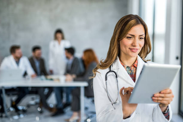 istock Female healthcare worker using digital tablet while standing in the office. 1432011986