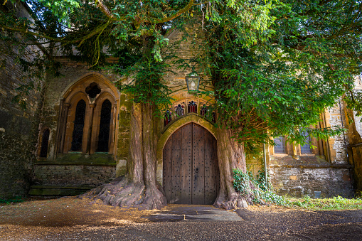 Stow on the Wold St Edward's Church magical yew tree door in the Cotswolds Gloucestershire of England UK. The wooden door was placed in the 13th century. The legend says that J. R. R. Tolkien visited Stow-on-the-Wold on his tours of the Cotswolds when he was an Oxford academic and inspired Doors of Durin in the Lord of the Rings.