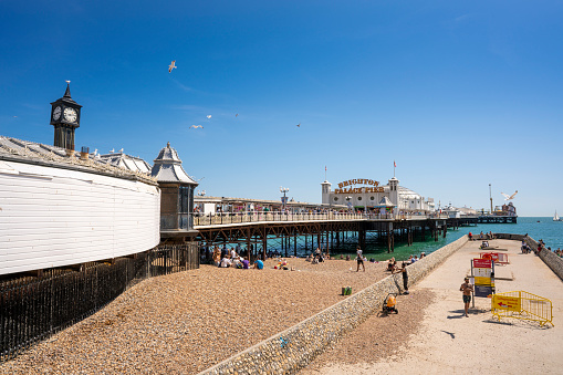 Brighton seaside resort beach and Brighton Palace Pier in a summer sunny blue sky day with tourists in UK, Great Britain, England in East Sussex 47 miles south London, called as 