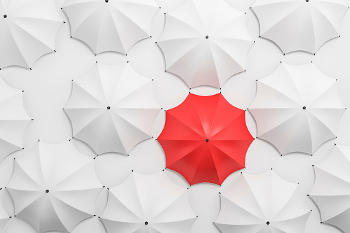 Red umbrella among white, stand out of the crowd. Concept of leadership and uniqueness. 3D rendering