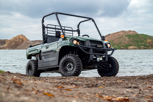 Berlin, Germany - 9th October, 2022: Kawasaki Mule PRO-MX next to the lake. The Kawasaki MULE (Multi-Use Light Equipment) is a series of very heavy Utility Task Vehicle that have been built by Kawasaki since 1988.