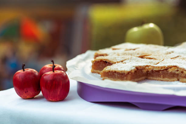 apple pie pieces sprinkled with powdered sugar, pastry on white plate, autumn backing, slice of sweet cake, selective focus on apples, copy space