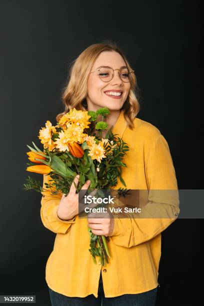 Studio Shot Of A Woman Holding A Bouquet Of Flowers Stock Photo - Download Image Now