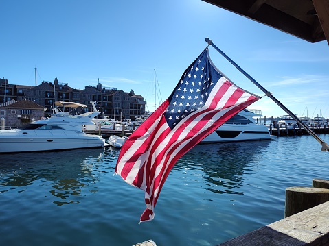 The US flag waving boldly at the boat marina.
