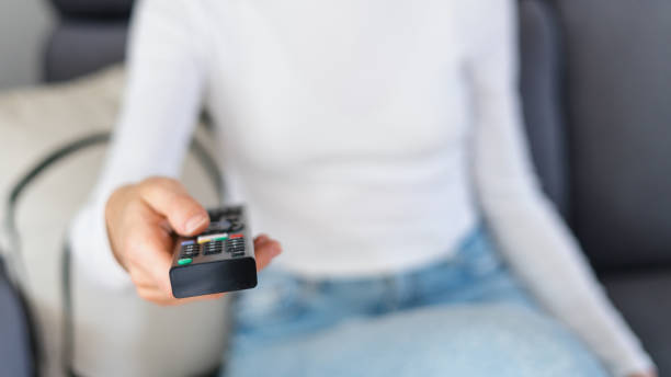 istock woman watching tv with remote control indoors 1432024058