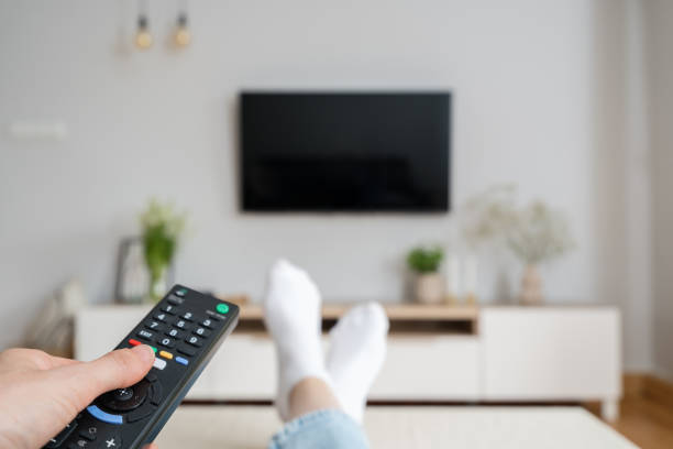 istock woman watching tv with remote control indoors 1432024073
