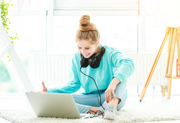 istock Cute girl using laptop in bright room 1432024138