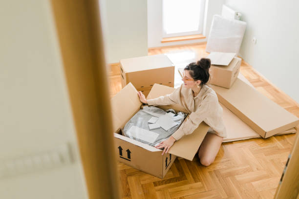 istock One woman, young lady moved into her new apartment, unpacking boxes alone. 1432024268