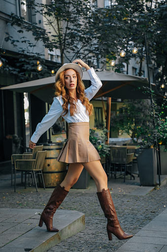 Outdoor portrait of young beautiful fashionable playful lady posing