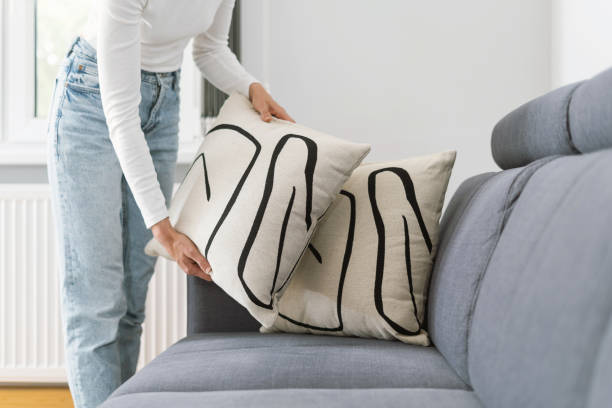 istock woman put decorative pillows on sofa in living room 1432025702