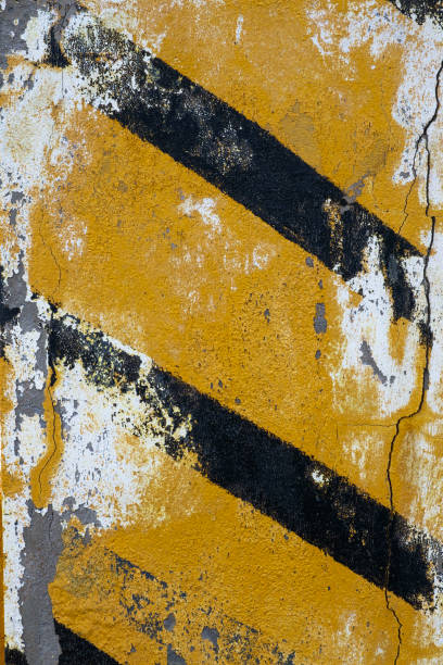 istock Black and yellow stripes on old concrete wall 1432032649