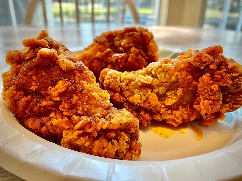 Three Nashville hot chicken wings in a plate.