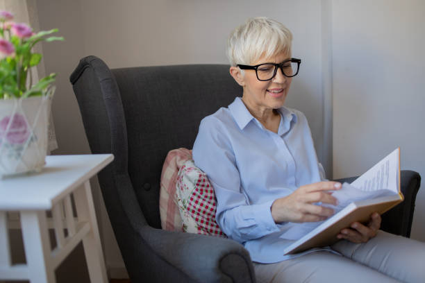 istock Happy woman reading book at home 1432034387
