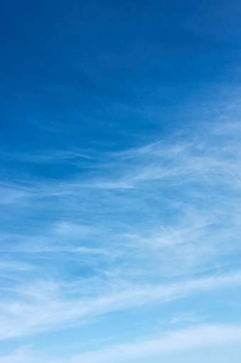 Blue sky with white fleecy clouds  - vertical background with space for your own text