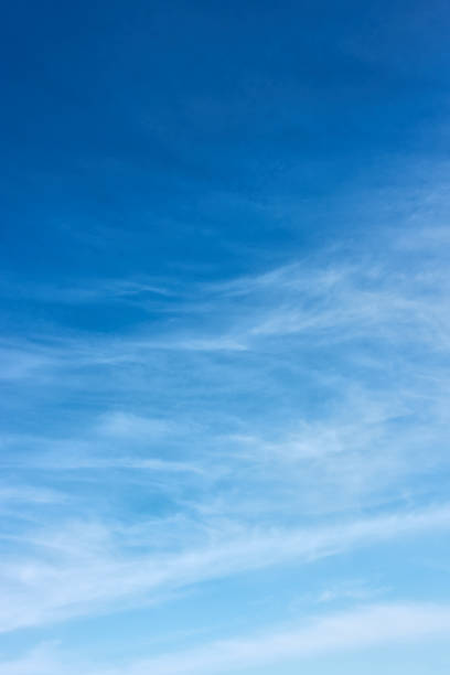 Blue sky with white fleecy clouds Blue sky with white fleecy clouds  - vertical background with space for your own text cirrus stock pictures, royalty-free photos & images
