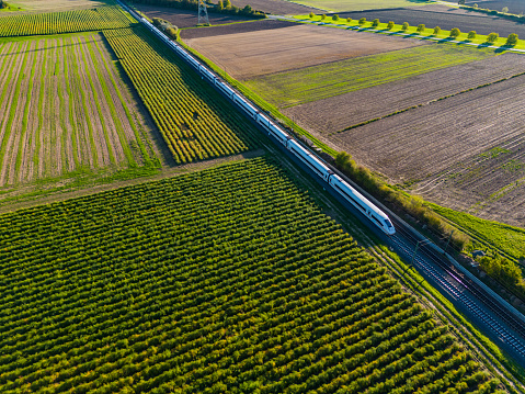 Aerial view of an electrified express ICE train on a railway track in rural area, Germany