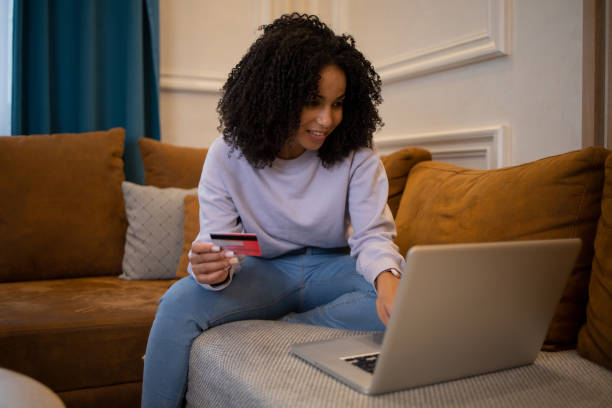 istock Cheerful  woman doing online shopping 1432046055