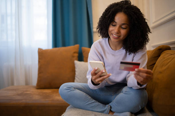istock Cheerful  woman doing online shopping 1432046063