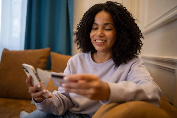istock Cheerful  woman doing online shopping 1432046070