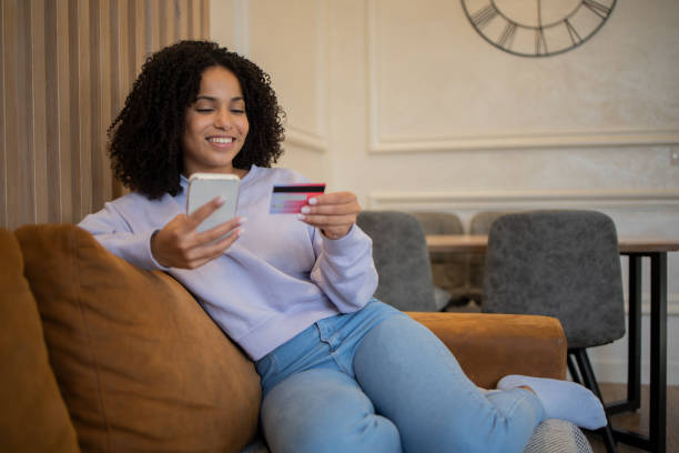 istock Cheerful  woman doing online shopping 1432046098