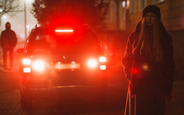 femme blonde en manteau dans la rue de nuit. temps brumeux. lumières de la ville. automne - detective spy women fashion photos et images de collection