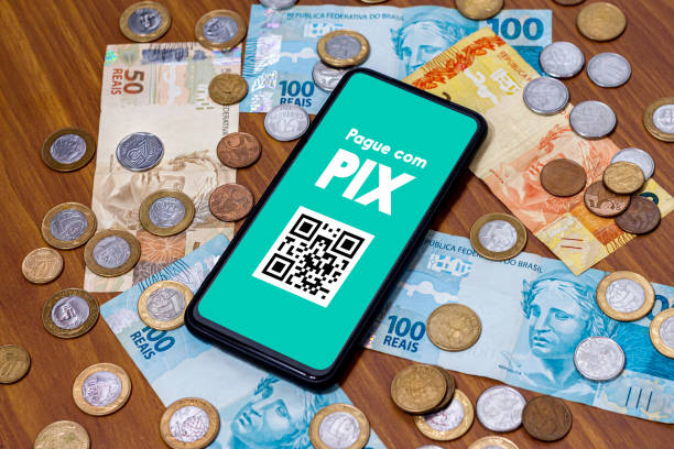 スマートフォンの画面上のpixは、周りに複数のコインがあります。pixは、ブラジルとブラジル政府の新しい支払いおよび転送システムです。 - digital photography ストックフォトと画像