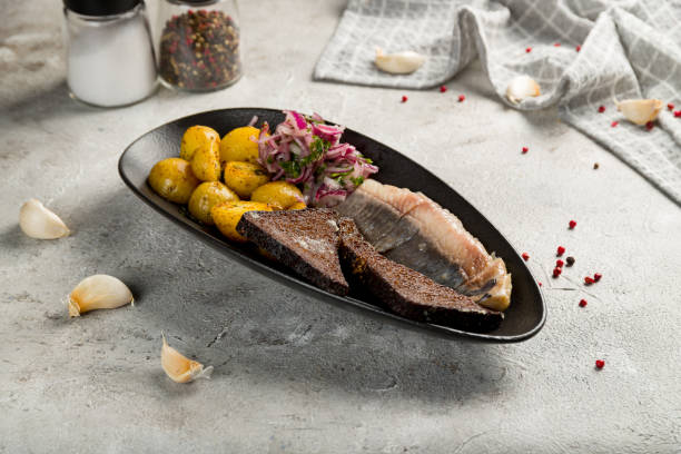 istock Herring with potatoes on black plate on grey table 1432056961