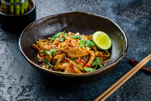 pad thai noodles with chicken on dark stone table - pad thai imagens e fotografias de stock